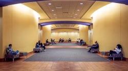 大学大厅内，几个人坐在走廊里.